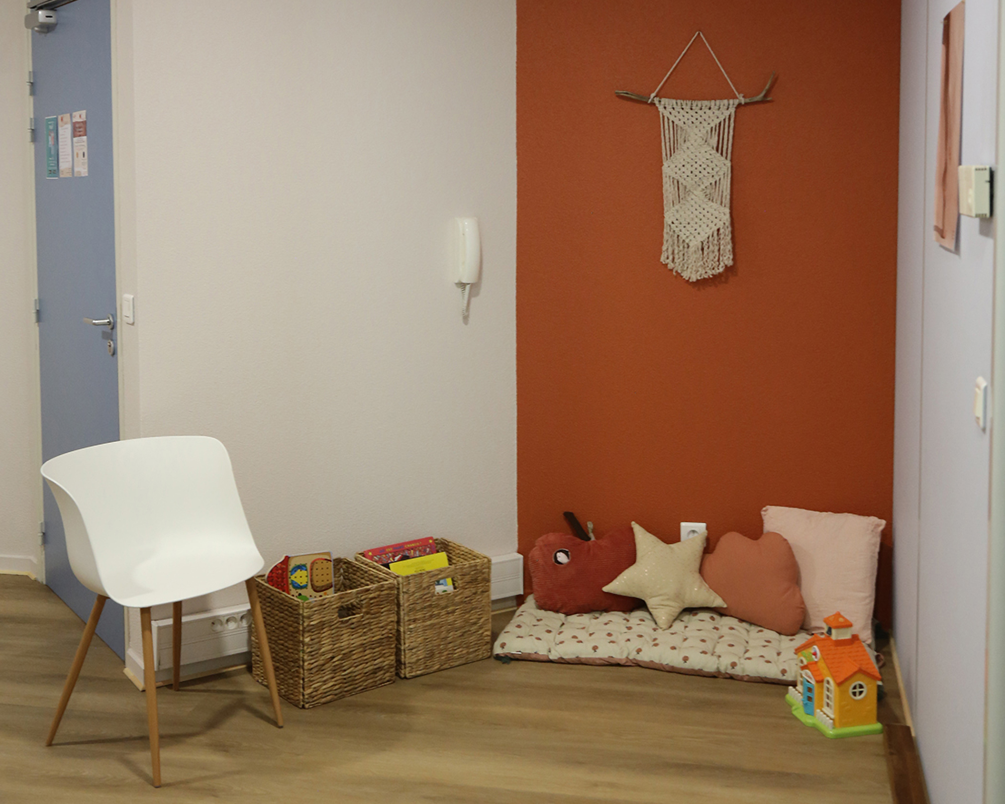 Photo de la salle d'attente équipée de matelas, coussins, livres et jouets pour les enfants.